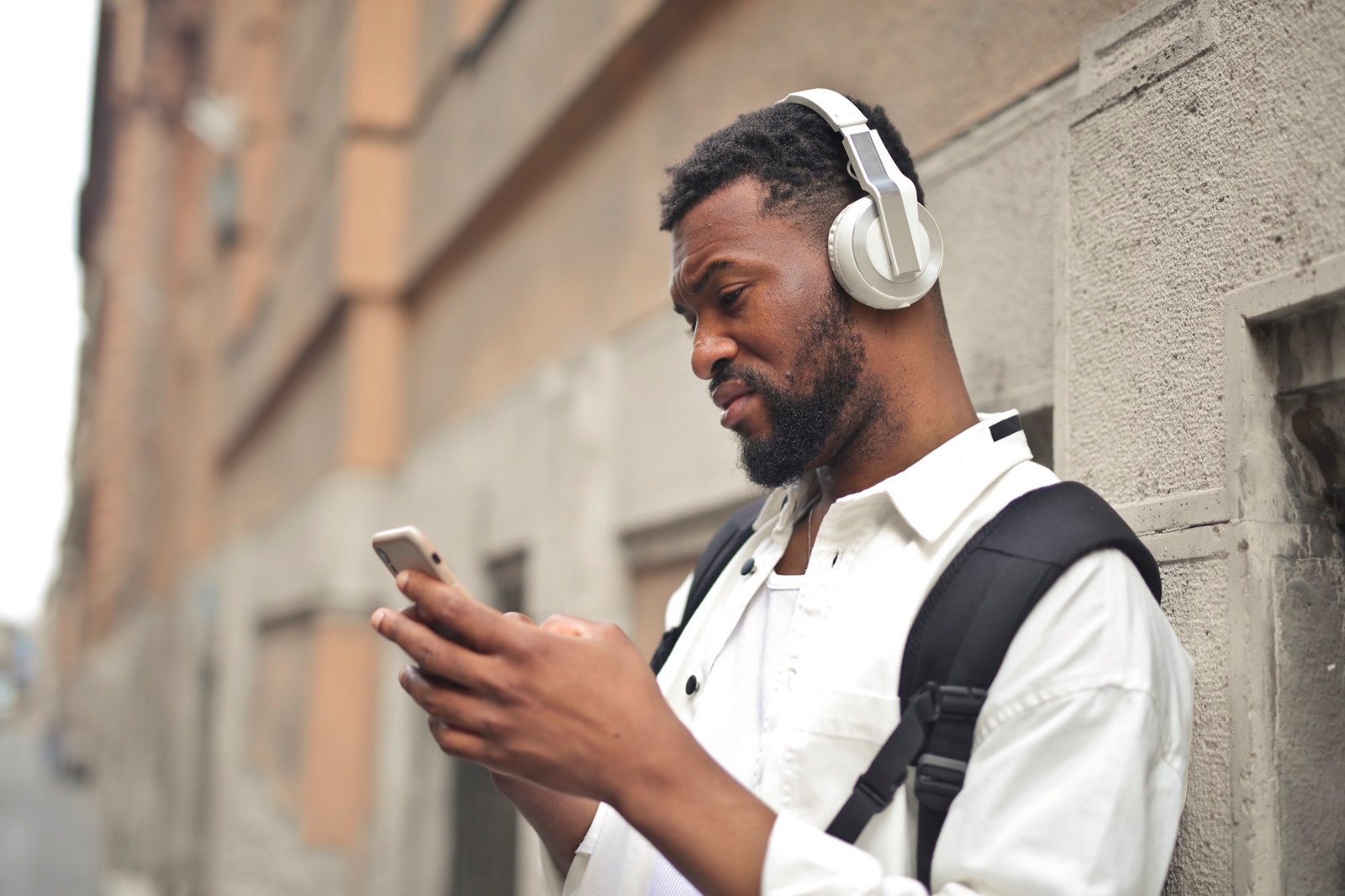 Un jeune homme consulte son téléphone dans la rue